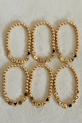 Gold Tone Ball Bead Bracelet With Black Stamped Letter Beads